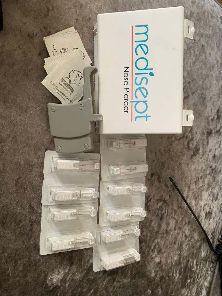 Nose piercing gun plus titanium studs. 