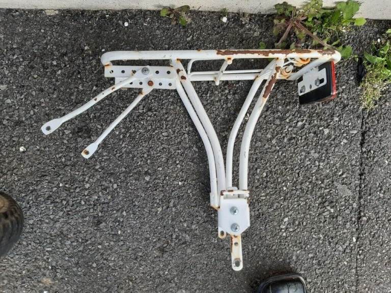 Small wheeled bicycle luggage rack with reflector.