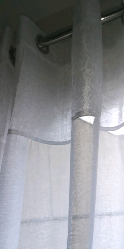Long sheer pair of white eyelets curtains 