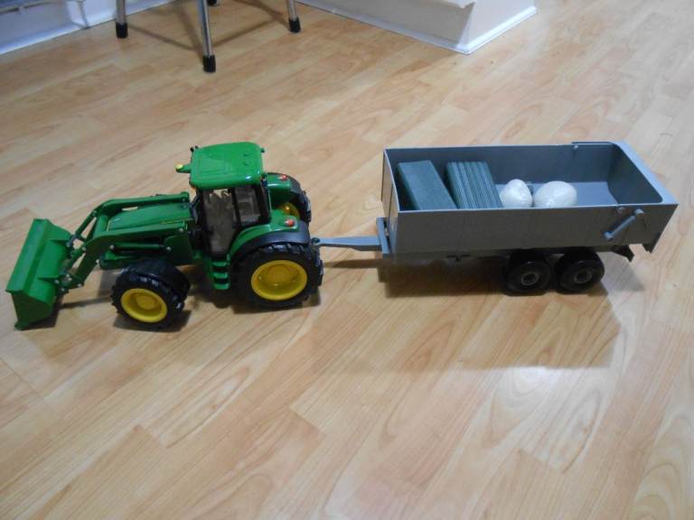 Large John Deere tractor with front bucket and tipping trailer
