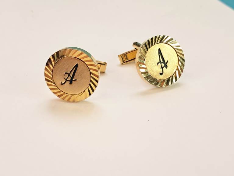 Vintage goldtone,round cufflinks featuring an engraved letter A and a radially textured edge.As Seen
