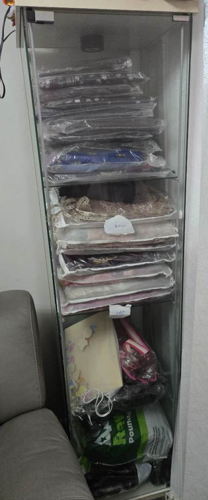 tall glass-door cabinet used for clothing and closet storage