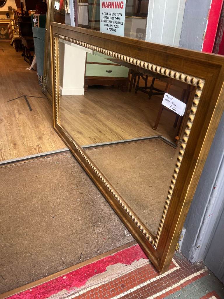 Gold ornate framed mirror , lovely detail .  