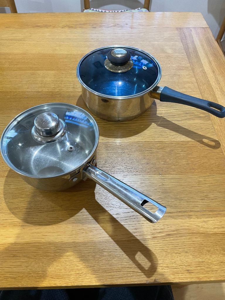 2 stainless steel saucepans with glass lids