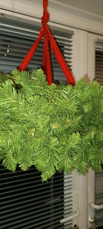 Thick hanging wreaths on red ribbons .