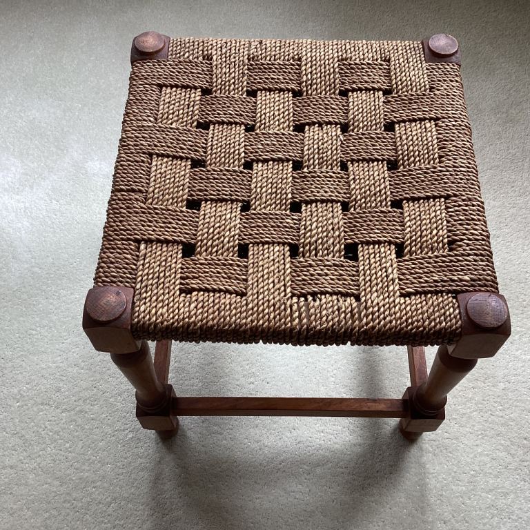 Wooden stool with firm weave top.