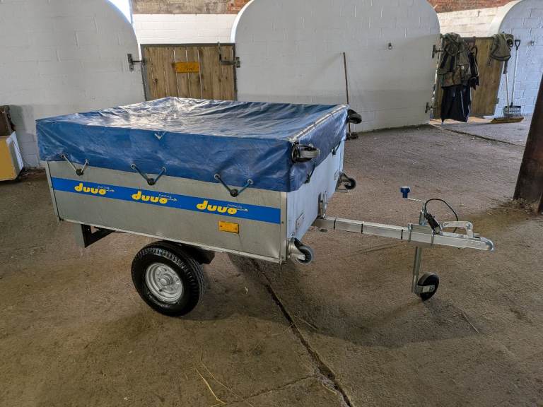 Duuo Easy Store Folding Trailer with accessories, stands upright to save space in garage.