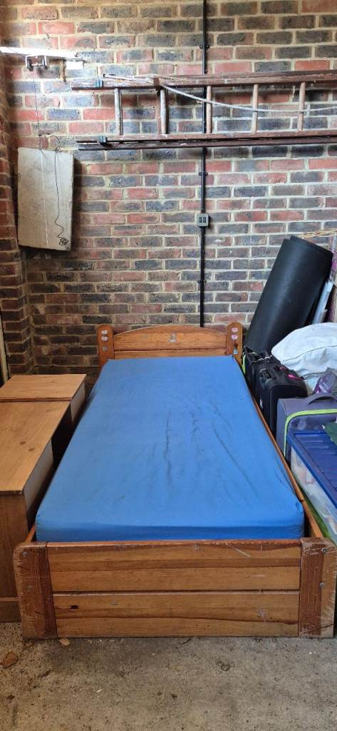 Wooden single bed frame with slats and a mattress