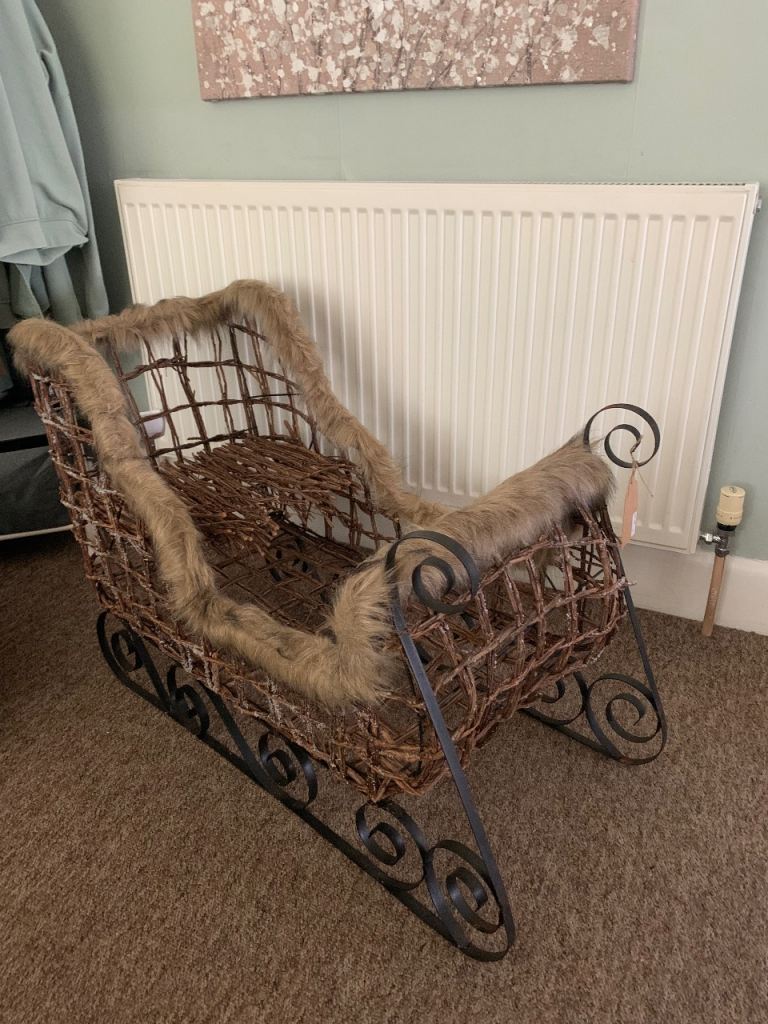 Christmas sleigh in wrought iron, wicker and fur 