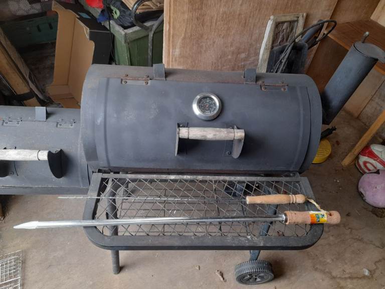 Smoking BBQ on wheels with temperature gauge and tools