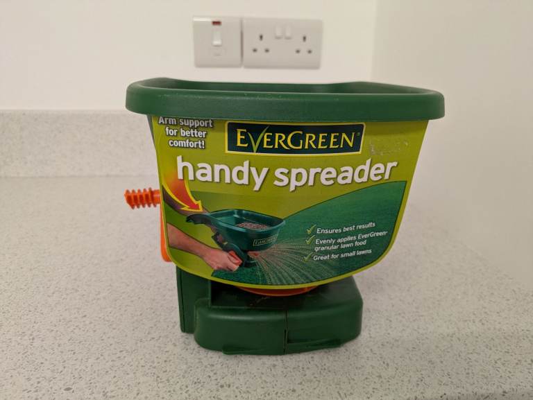 Evergreen handheld spreader for granular feed and grass seed