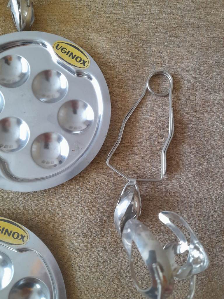 Vintage Uginox escargot stainless plates and holding tongs.Might interest collectors or hoteliers