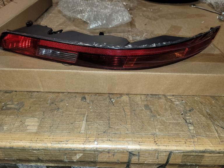 A new still boxed Left Rear Bumper Lower Tail Light Rev