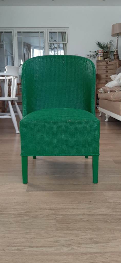  A vintage Lloyd Loom style green painted wicker nursing chair with lower drawer