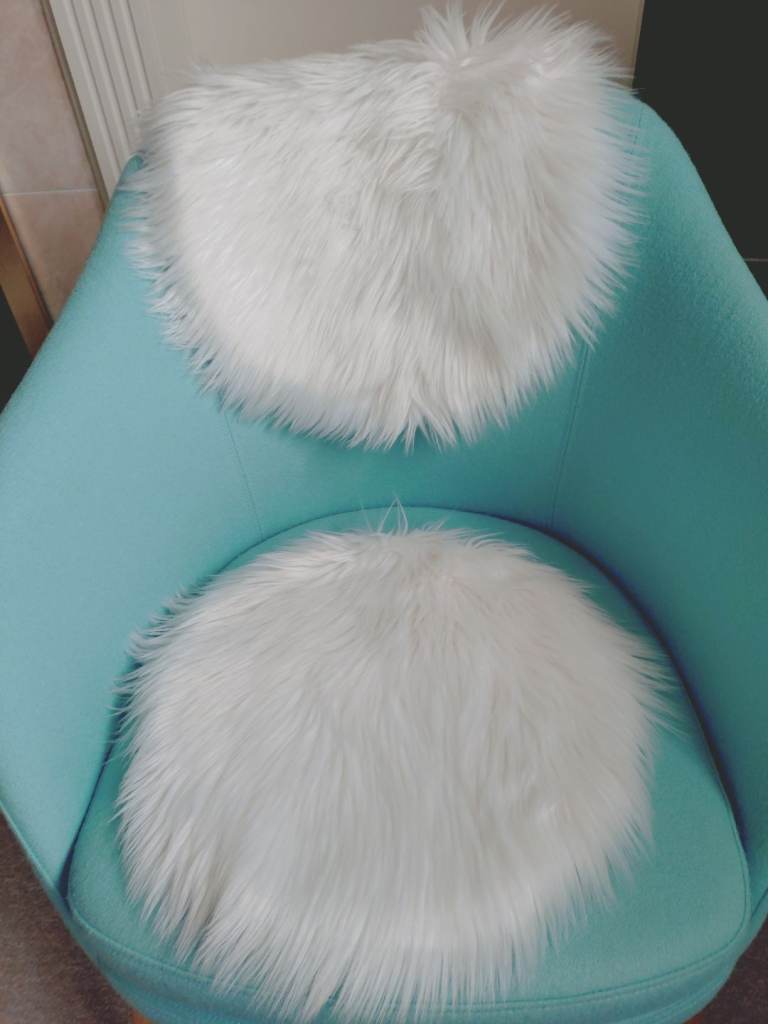 A set of 2 faux fur white chair pads