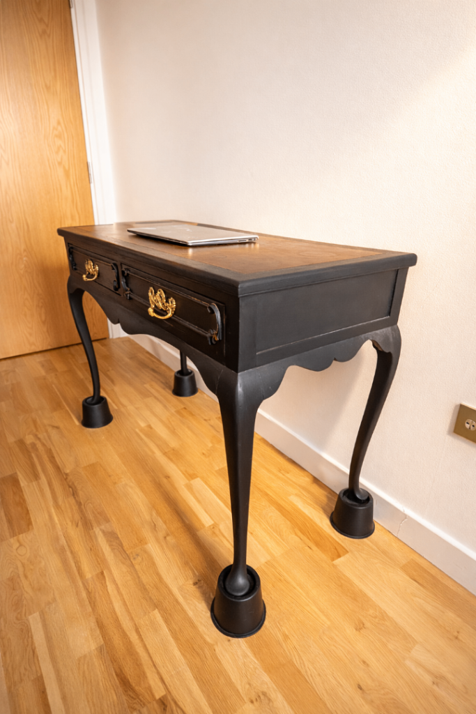 Elegant classic-style desk with a black finish and decorative gold handles.