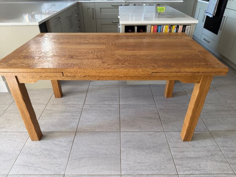 Solid oak extendable dining table and 6 solid oak chairs with black leather seats