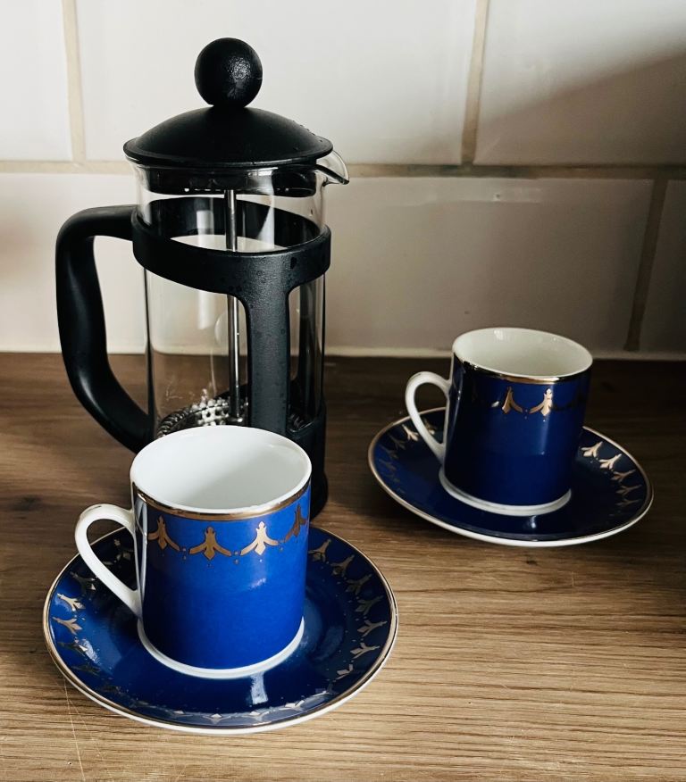 Coffee Press with Two Blue Espresso Cups and Saucers