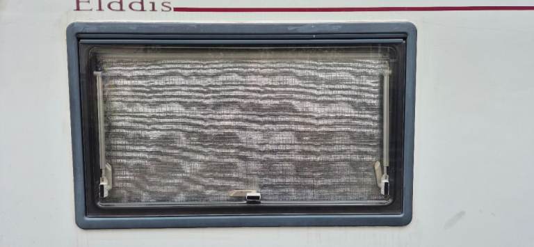 Windows with frames, blinds and flynet for van conversion.