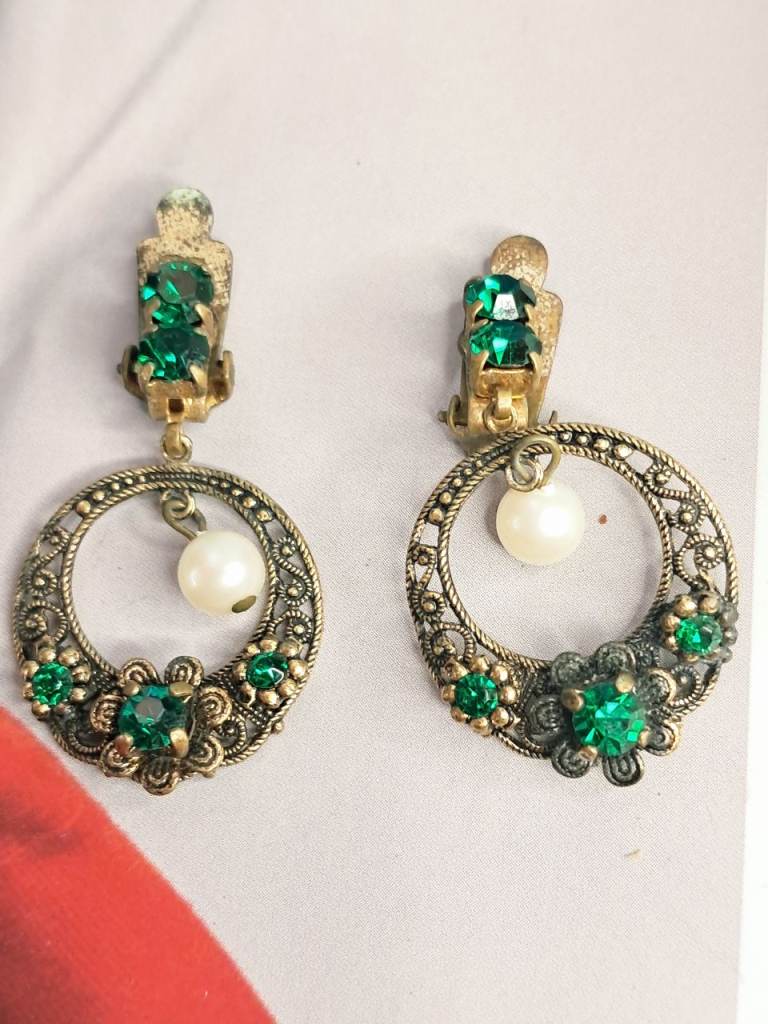 vintage-style costume jewelry featuring gold-tone filigree hoops adorned with green rhinestones
