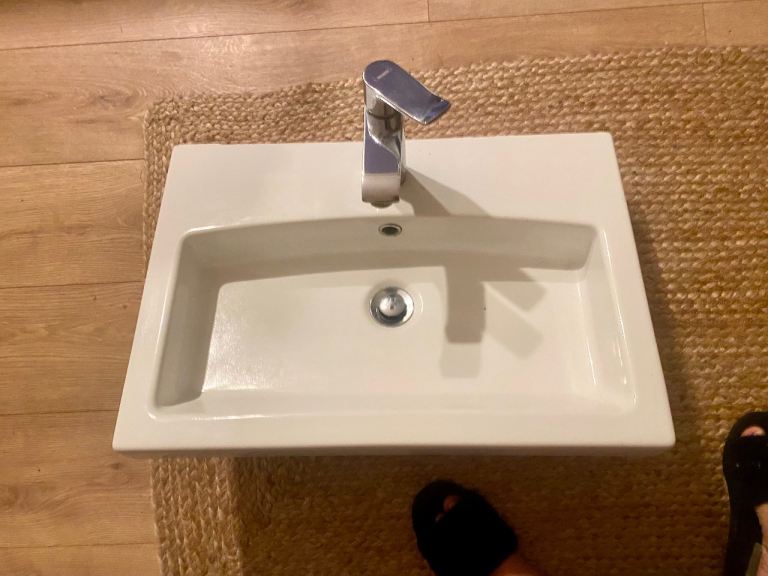 Large rectangle white bathroom sink and taps