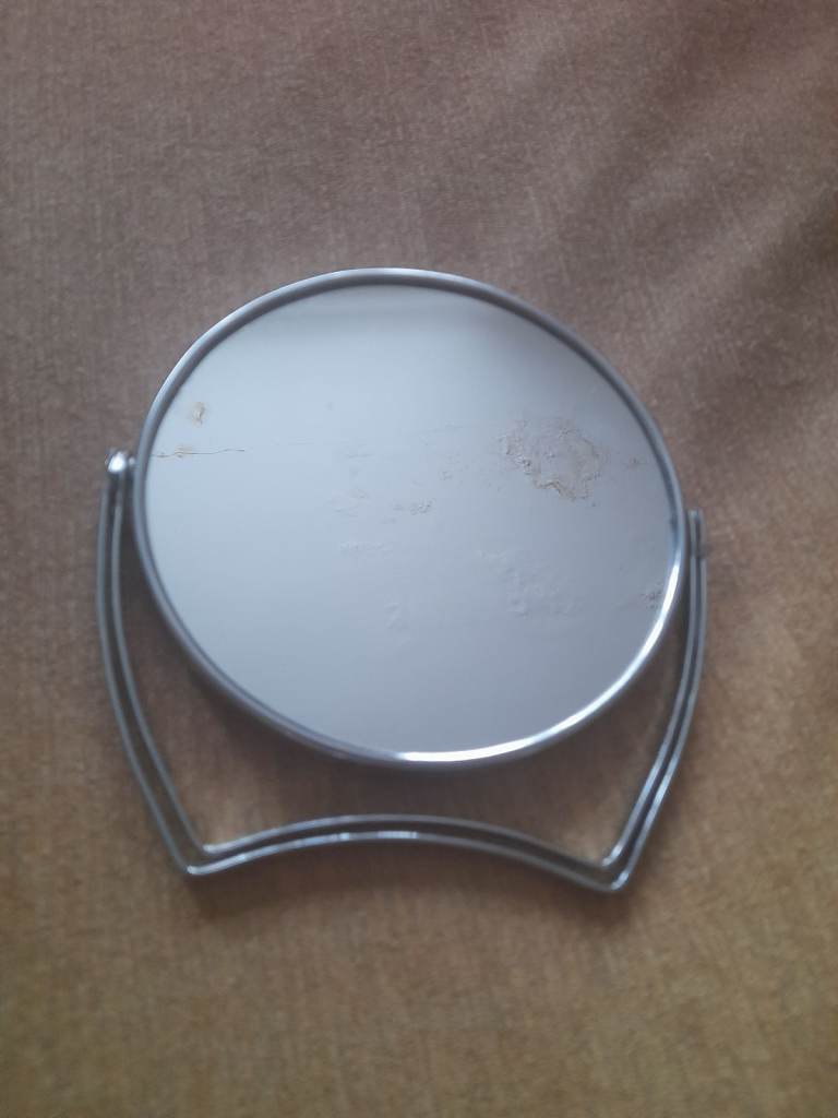 Stainless steel, double sided mirror with a pedestal. Plain and magnified.