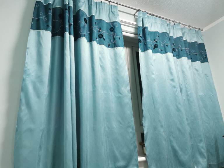 2 light blue curtains with a white lining. With 2 pillowcases, the set is 180 