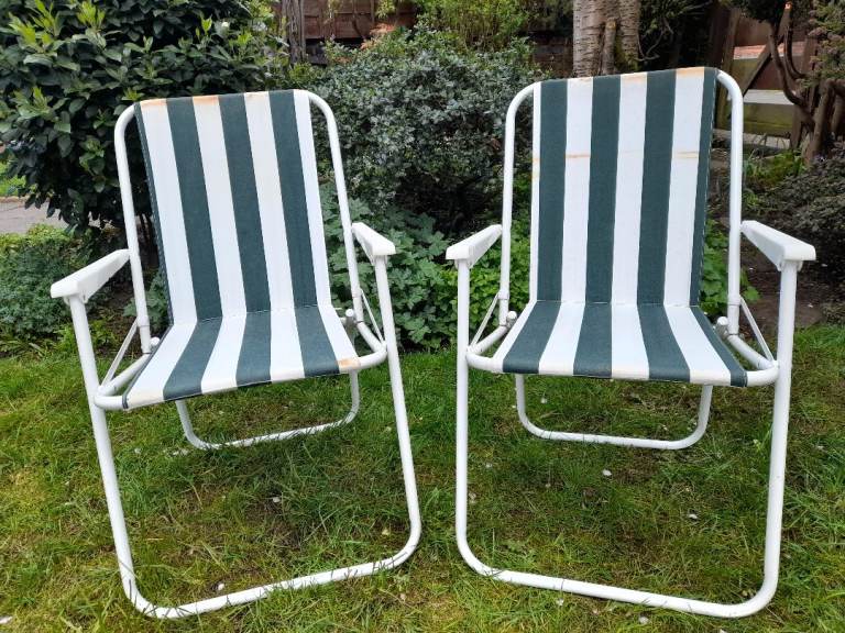 Two small,striped folding deckchairs