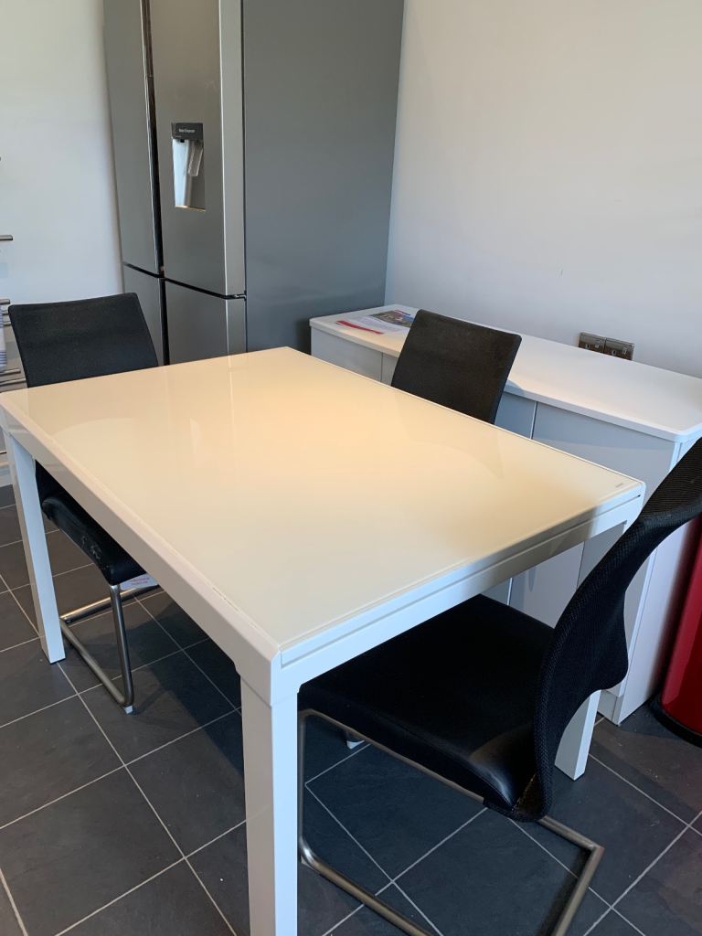 White extending table, black chairs and sideboard