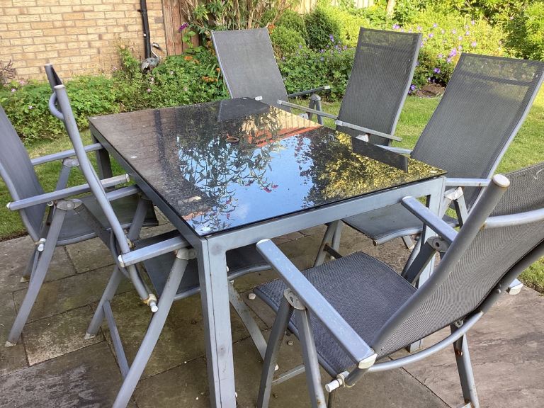 Garden table and 6 folding chairs grey with black glass free to collect 
