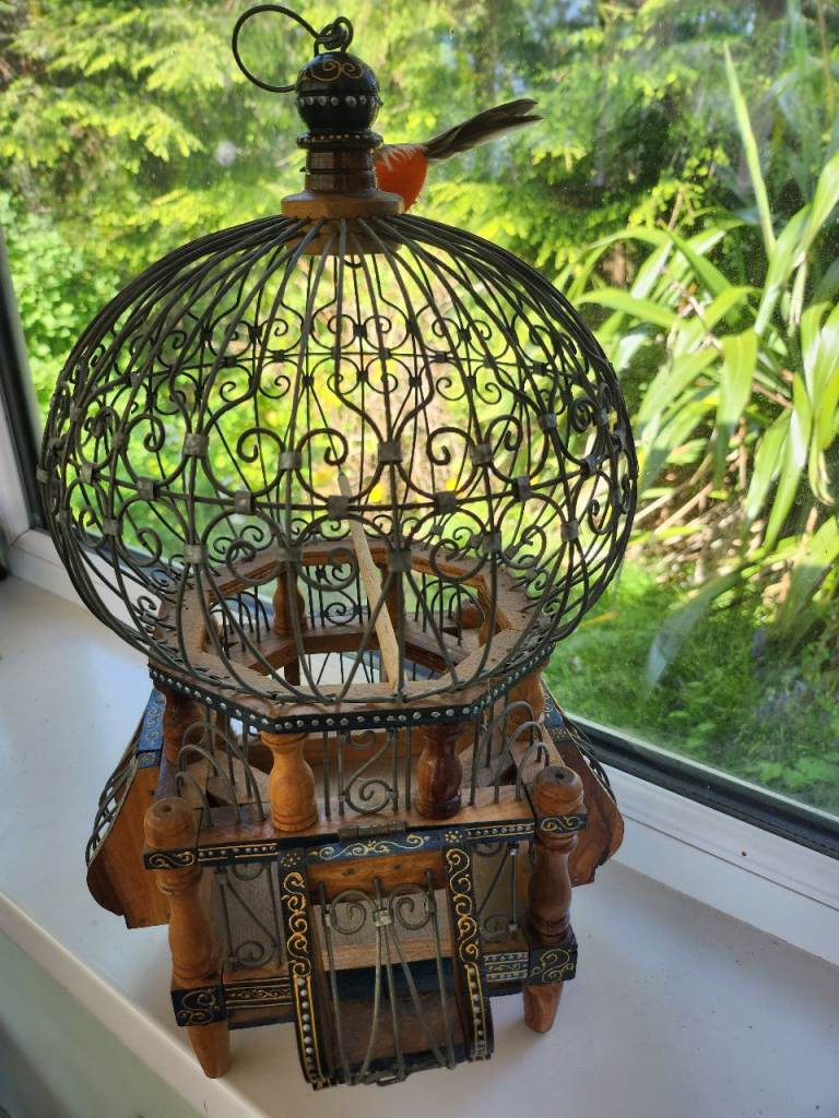 Ornate bird cage of metal and wood