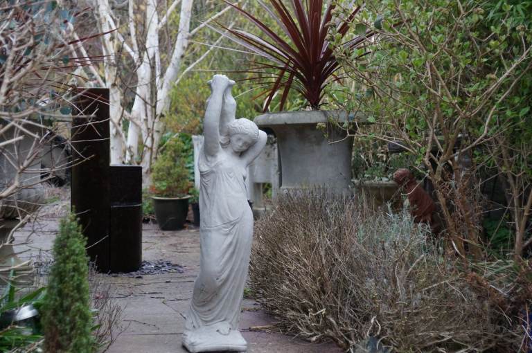 A garden statue carrying jug