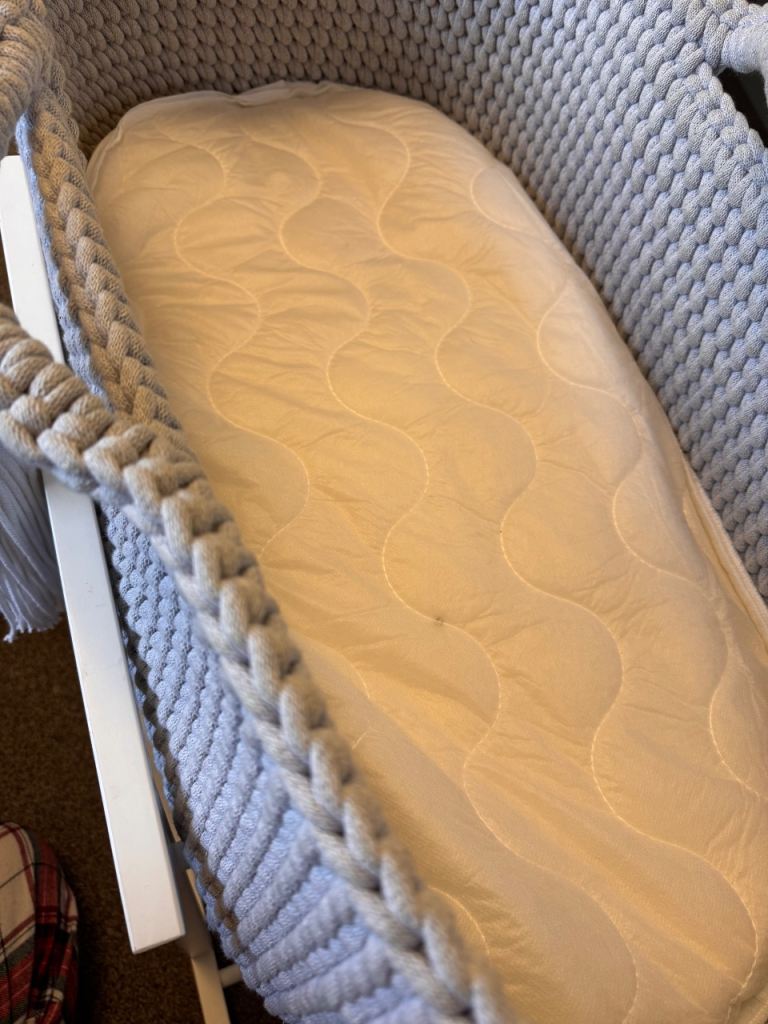 Light grey crochet crib with white wooden stand 