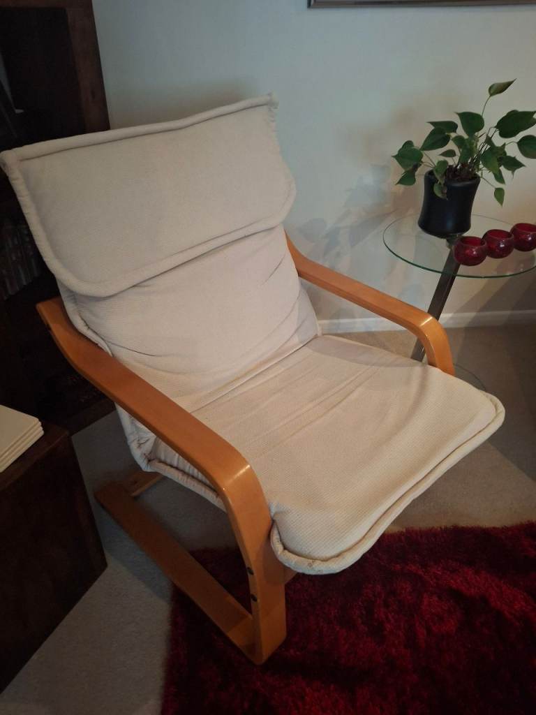 Armchair with a light-wood frame and a light beige cushion. 