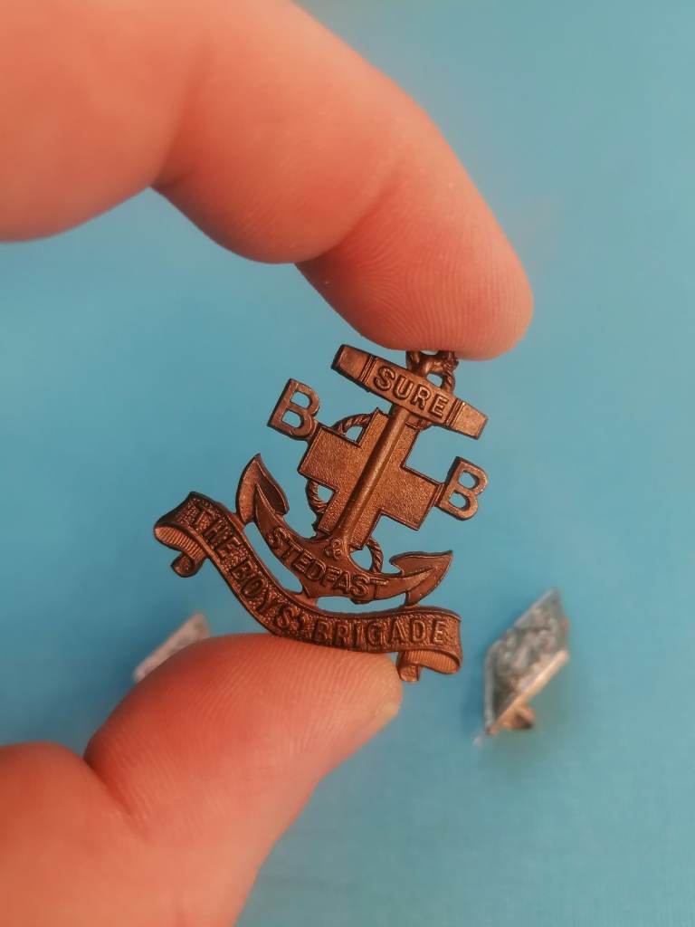 The badges, brooch are vintage, dating back to the World War II era.
