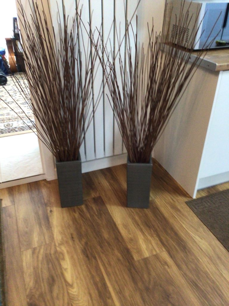 Two ceramic square vases with twigs.