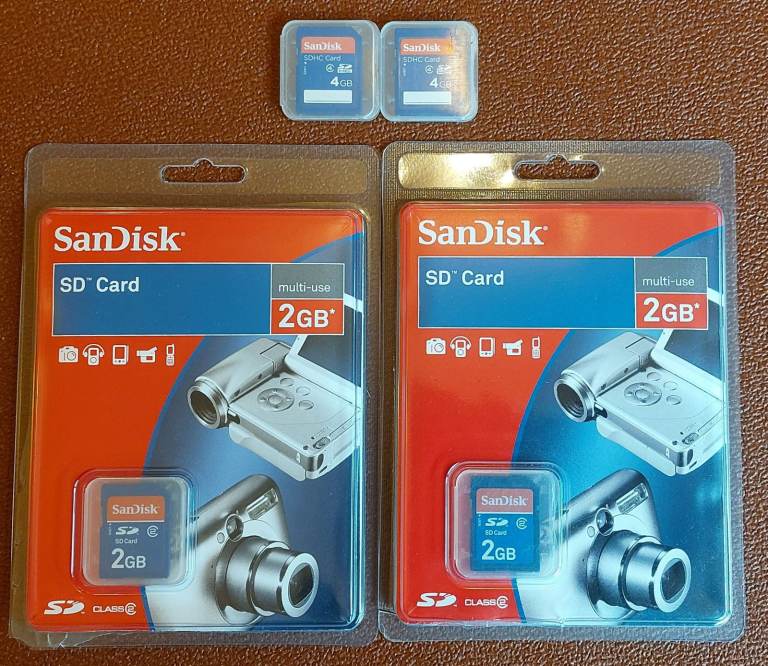 Two 4GB and two 2GB blank used Sandisk SD memory cards in their original plastic holders