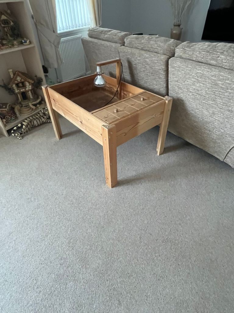 Wooden tortoise table with basking lamp and unopened 20kg sack of bedding pellets