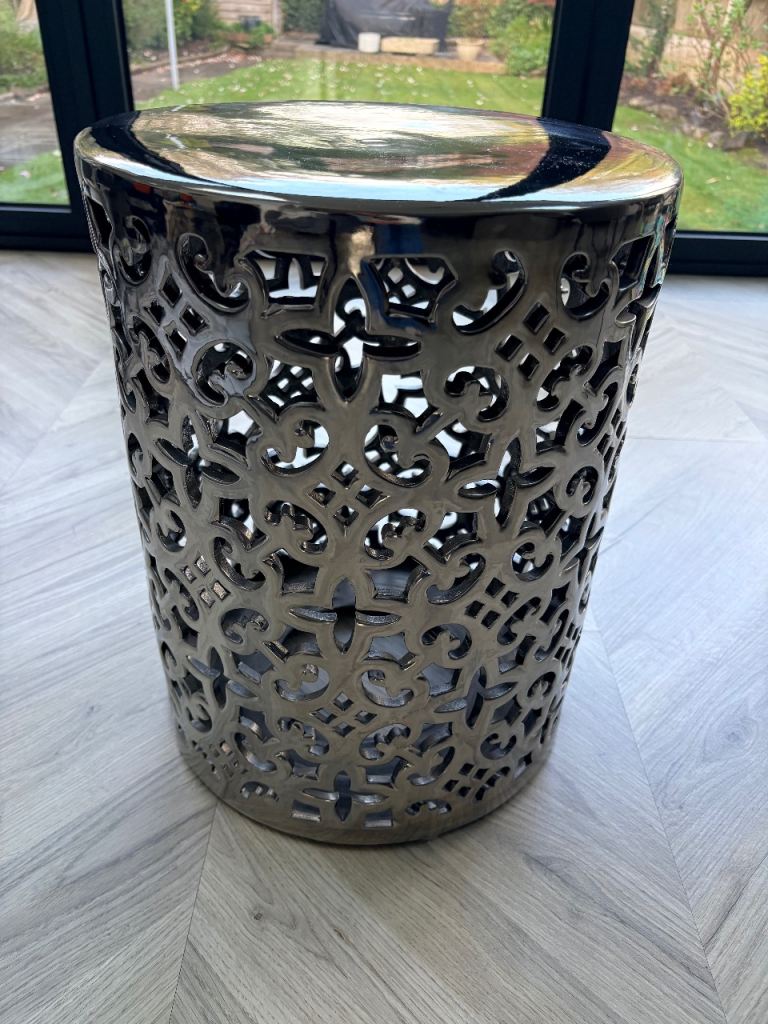 Silver appearance side table with cut out design 