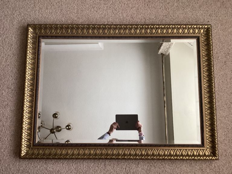 Mirror with brass colour trim