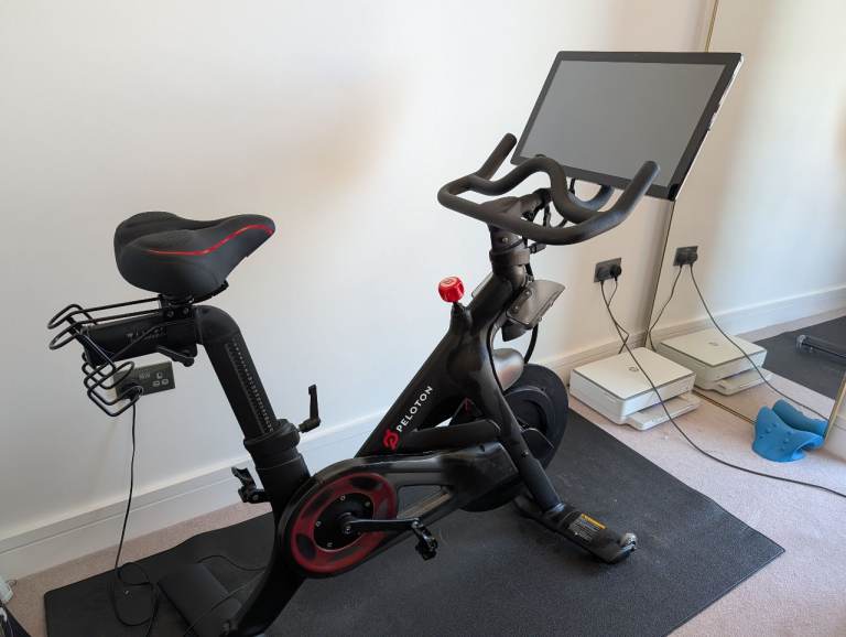 Peloton exercise bike - good condition with mat & padded seat