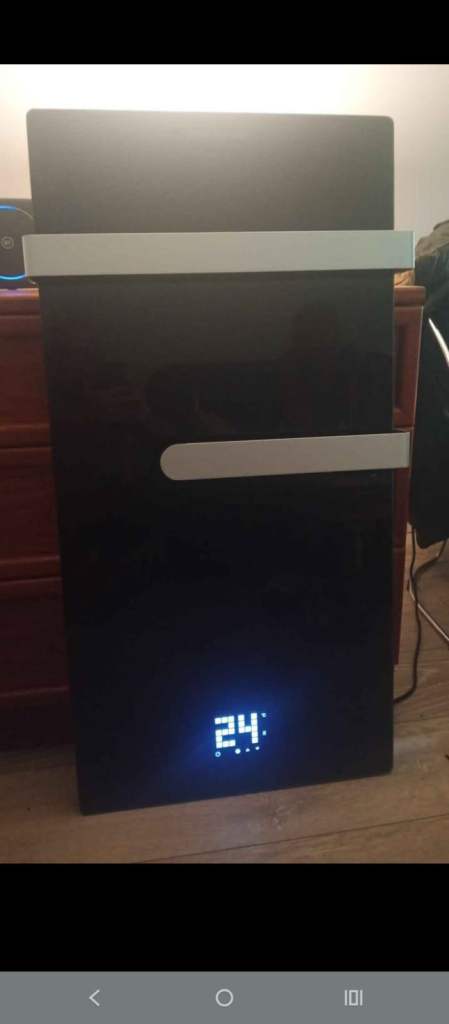 Black glass electric heater suitable for wall mounting with 6 screws.