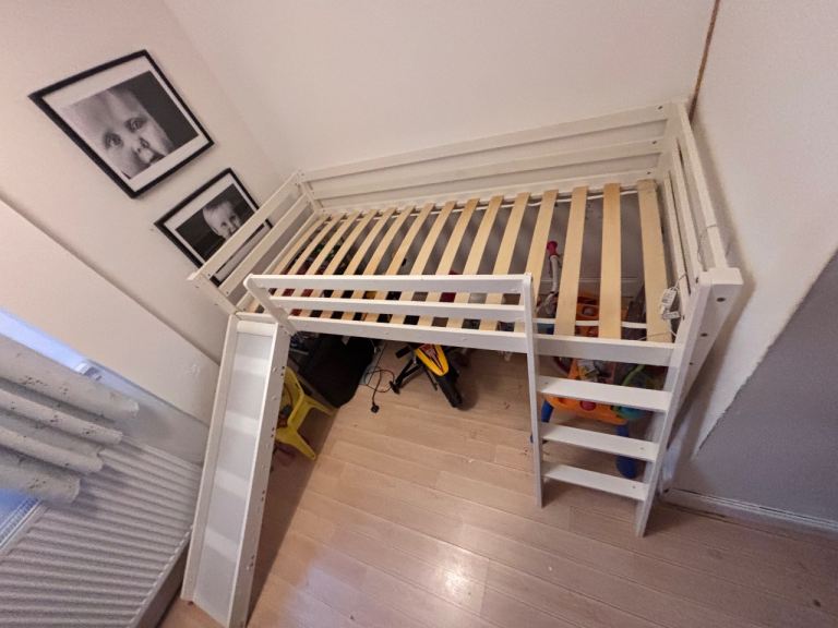 Kids single bed raised with a slide. 