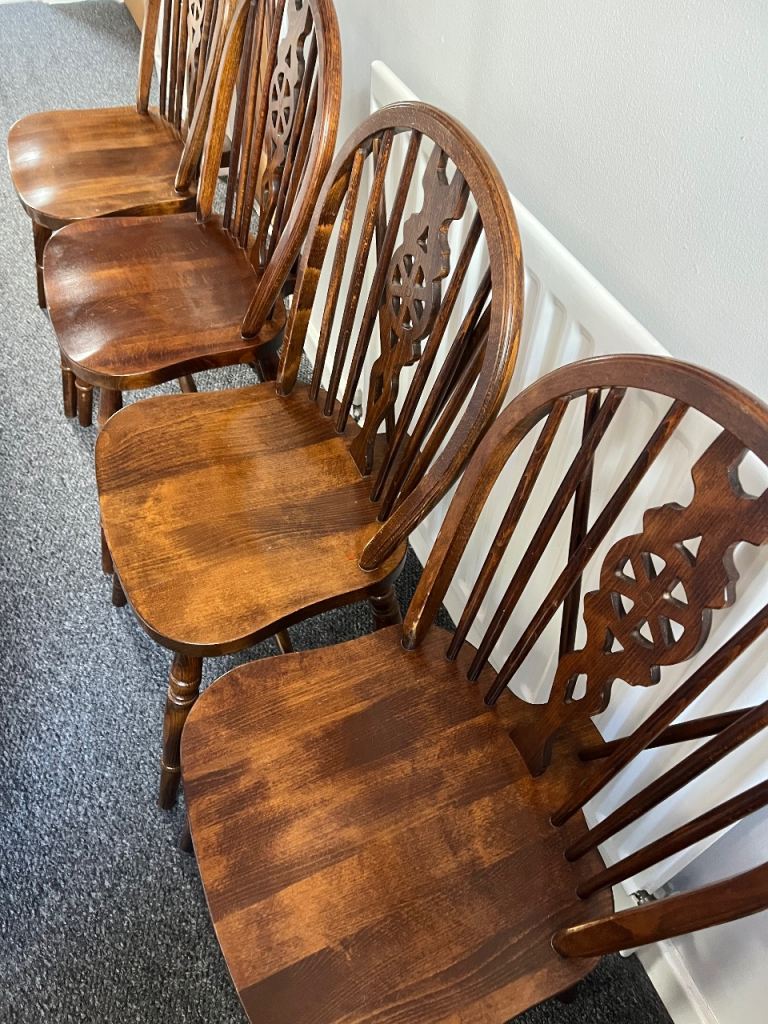 A set of four vintage wheel back dining chairs. 
