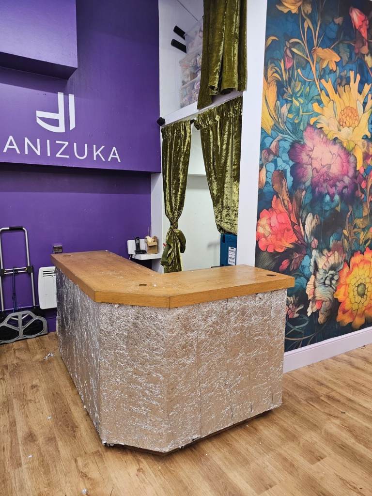 L-shaped wooden reception desk/shop counter with built in shelves 