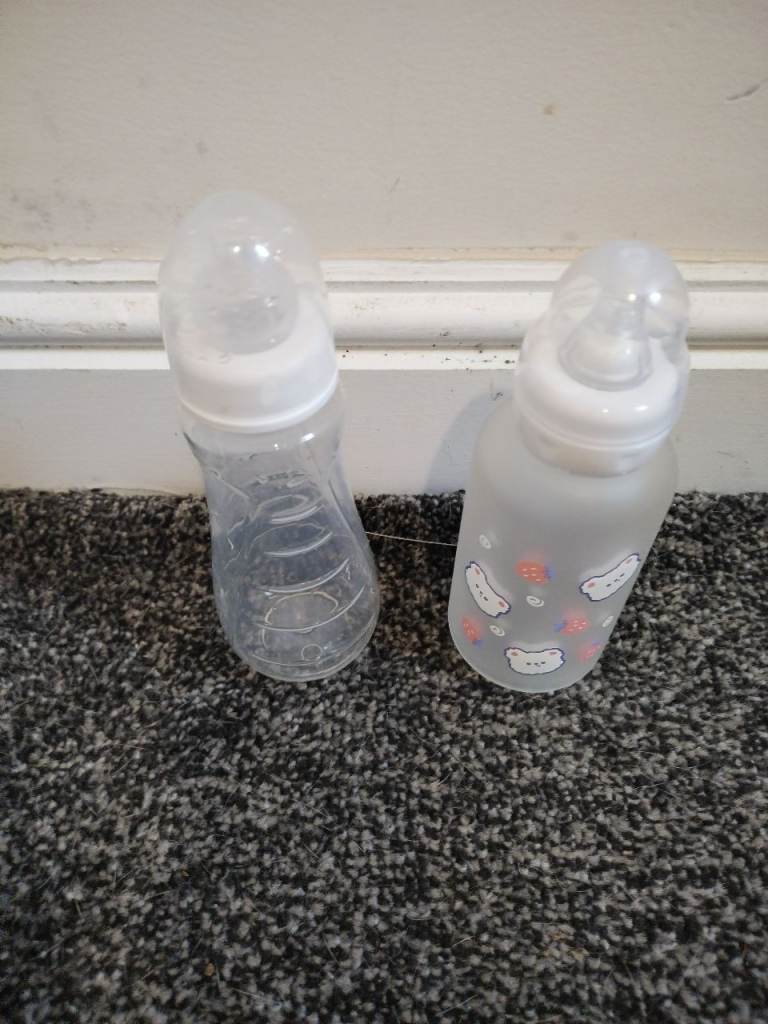 Adult feeling child drinking bottles 