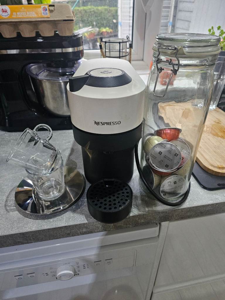 Nespresso veturo pod coffee maker machine in white with Nespresso cups/saucers, storage jar and pods