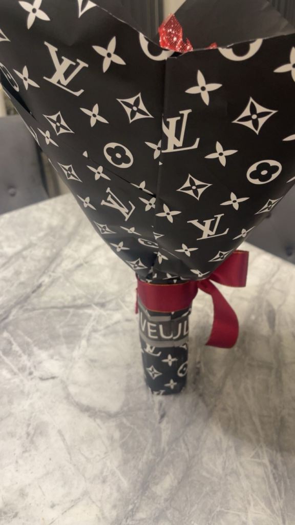 Red roses with diamonds on it wrapped in paper