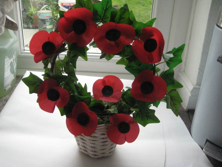 Artificial Poppy Flower and Leaf Arrangement in Pot Displayed in White Wickerwork Basket: £5.00