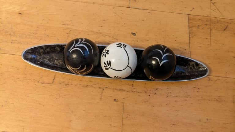 Decorative enamelled metal tray with 3 wood balls centrepiece